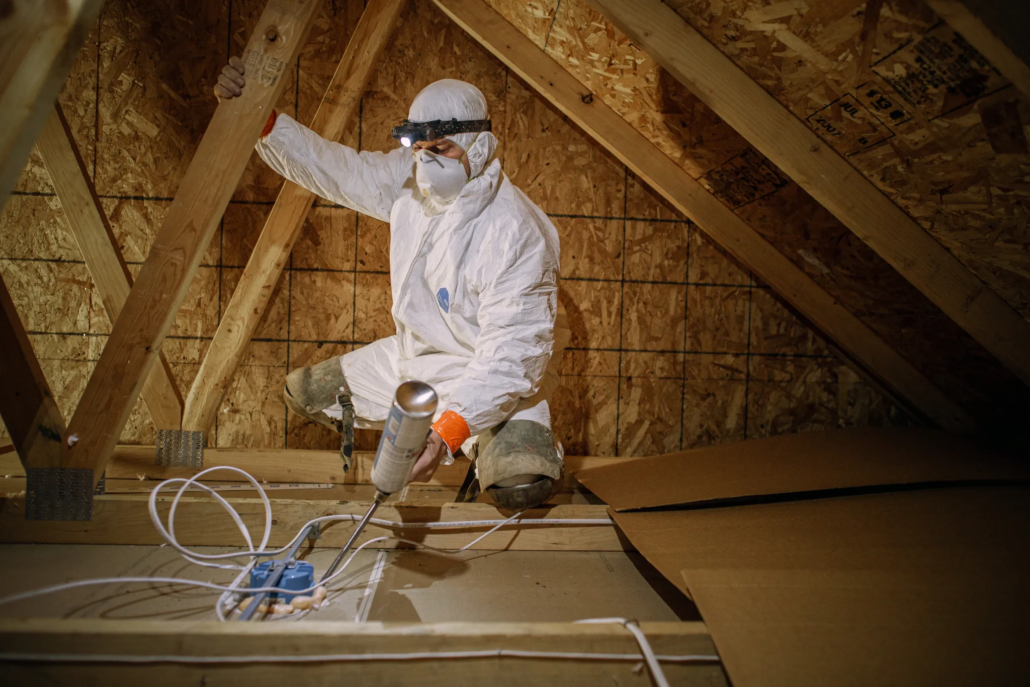 Laundry basket full of clothing in front of a washer and dryer.